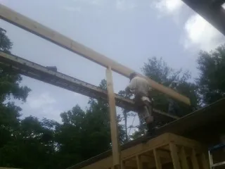 Carpenter setting a ridge beam over a new addition frame — Ice Dam Removal by Roofing Brothers in Tres Pinos