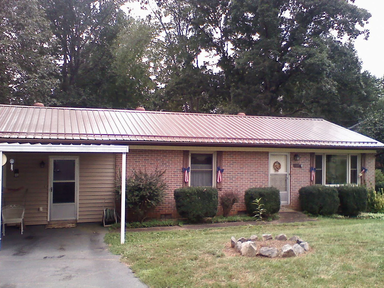 Bronze metal roof and carport on a brick ranch home — Roof Repair work by our crew in Tres Pinos